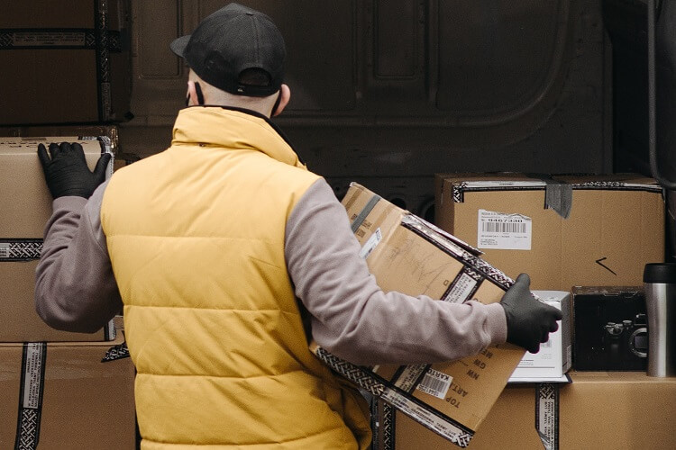 courier unloading package with bad manual handling which is one of the risks to delivery drivers